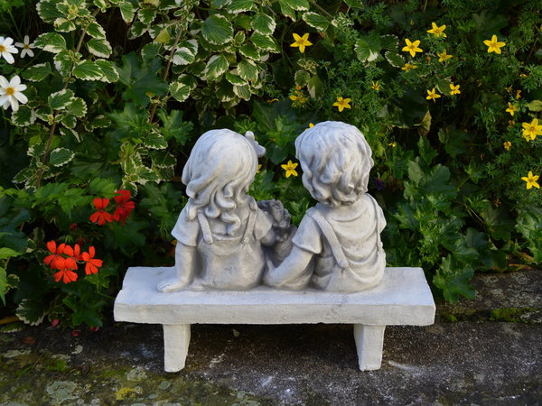 Zwei Kinder-Figuren auf der Bank