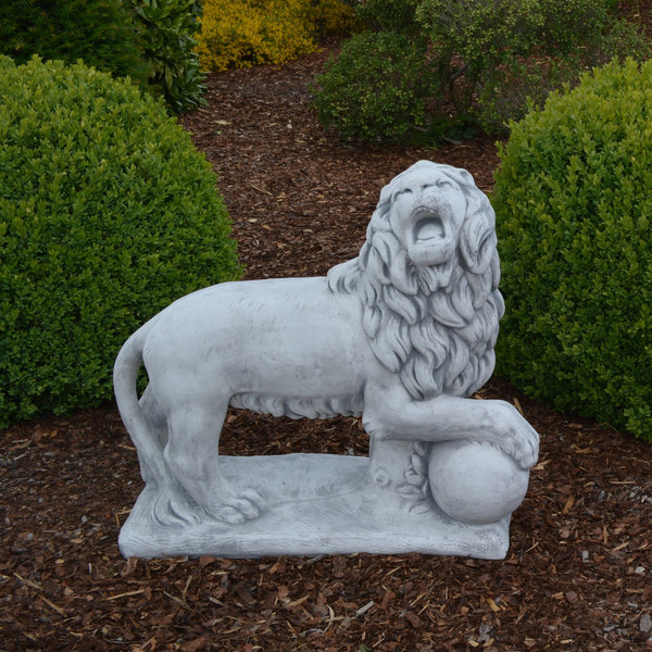 Lion with ball on stone slab looking to the right