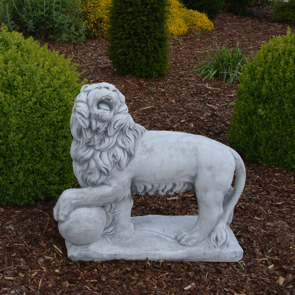 Lion with ball on stone slab looking left